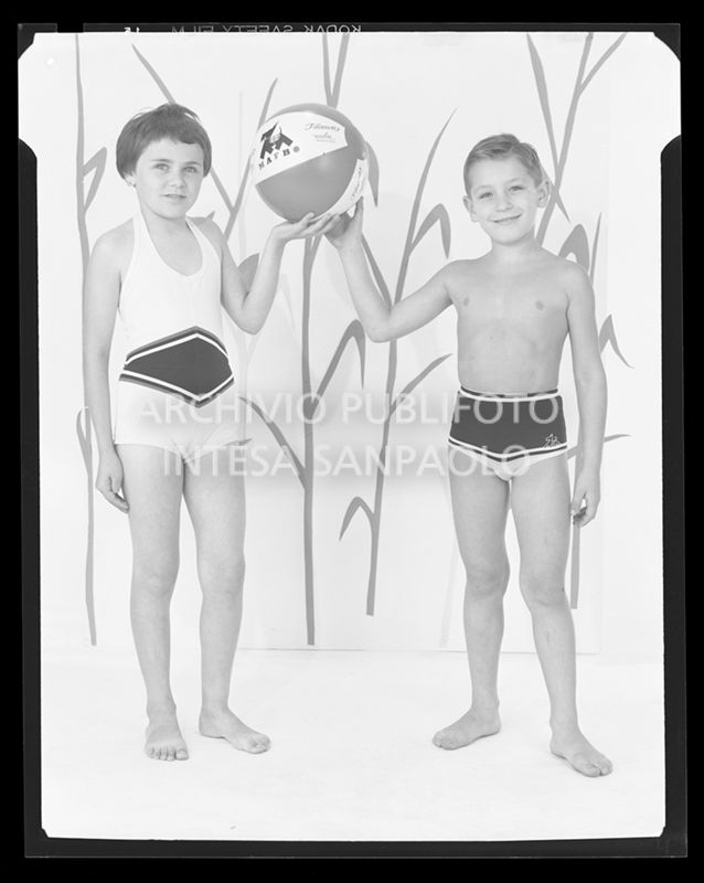 Bambina con costume intero e bambino con costume a pantaloncino con palla con la scritta "Mafbo Filanca"<br>21225