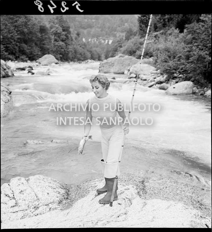 Donna con canna da pesca e pesce in mano<br>5248