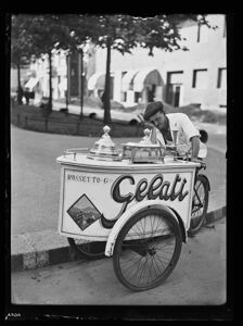Un gelataio ambulante si riposa appoggiato al carretto per la vendita
