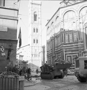 A sinistra una bancarella con frutta e verdura, sullo sfondo il battistero e il campanile di Giotto.<br>