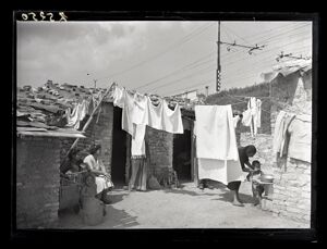 Donne e bambini alle Case Minime dell'Ortica, sono visibili i panni appesi ad asciugare tra le abitazioni