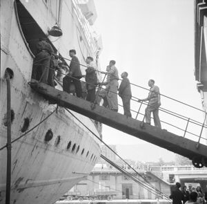 Emigranti italiani sulla passerella di accesso alla nave che li porterà in Argentina, attraccata nel porto di Genova