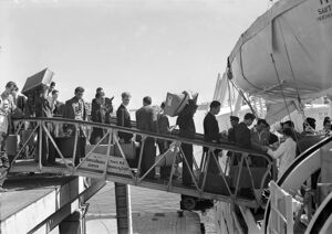 Emigranti italiani sulla passerella di accesso al piroscafo Santa Fe ,che li porterà in Argentina, attraccato nel porto di Genova