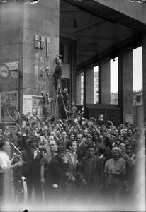 Folla di persone festeggia la caduta del governo Mussolini, in via Carlo Alberto (oggi via Mazzini), a Milano, demolendone i suoi simboli, i fasci littori