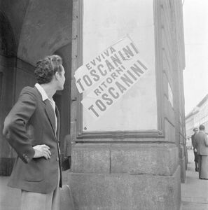 Un uomo guarda i manifesti "Evviva Toscanini", "Ritorni Toscanini" affissi all'esterno del Teatro alla Scala di Milano