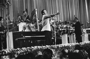 Domenico Modugno, si esibisce sul palco del salone delle feste del Casinò al Festival di Sanremo, che vincerà, insieme a Johnny Dorelli, con la canzone "Piove"
