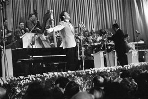 Domenico Modugno, si esibisce sul palco del salone delle feste del Casinò al Festival di Sanremo, che vincerà, insieme a Johnny Dorelli, con la canzone "Piove"