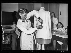 Maestra di taglio e cucito, in aula durante la lezione, al lavoro su un manichino