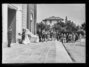 Una sposa, al braccio di un uomo, entra in chiesa seguita dal corteo degli invitati