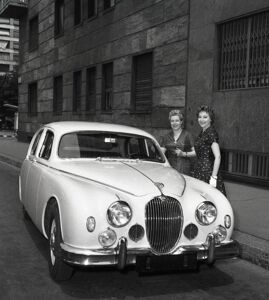 La soprano lirica Franca Duval, in compagnia di un'altra donna, vicino a una Jaguar Mark I