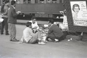 Immigrati dal Sud Italia mangiano sulla banchina alla Stazione Centrale di Milano
