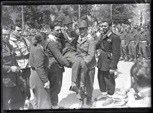 Un gruppo di partigiani, tra cui un ragazzo ferito portato a braccia dai suoi compagni, durante la manifestazione  in piazza Castello a Milano in onore delle formazioni partigiane