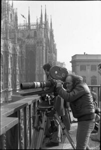 Un operatore di Cinecittà mentre riprende piazza del Duomo dalla balconata dell'Arengario