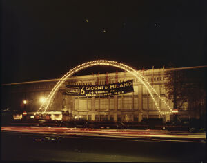 Visibile un'impalcatura ad arco luminosa ed uno striscione con la scritta "6 Giorni di Milano 2-8 febbraio 1961 Organizzazione Ignis"