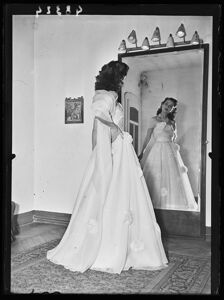 Una donna in abito elegante si guarda allo specchio