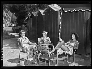Tre donne, in abiti estivi e costume da bagno, sedute al tavolino di uno stabilimento balneare a Portofino