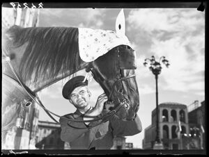 Vetturino mentre accarezza il muso di un cavallo in piazza del Duomo a Milano