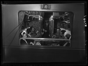 Controllore ferroviario vidima i biglietti ai passeggeri seduti nello scompartimento di un treno