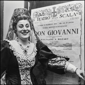 Il soprano Antonietta Stella, in costume di scena, posa a fianco alla locandina del "Don Giovanni" di Wolfgang Amadeus Mozart, in scena al Teatro alla Scala