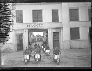 Operai della Piaggio & C. in sella alla Vespa davanti all'ingresso dello stabilimento a Pontedera