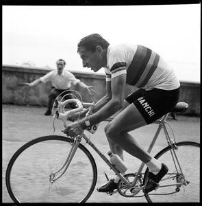 Fausto Coppi impegnato nella 15° tappa del Giro d'Italia 1954, da Gardone Riviera a Riva del Garda, incitato da un tifoso