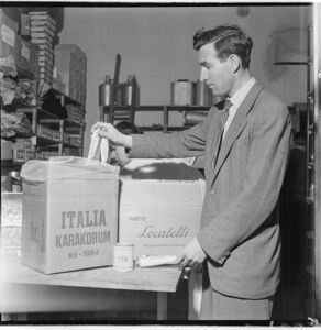Sugli scatoloni le scritte: "Italia Karakorum K2 1954 e "Tubetto Locatelli. Triplo concentrato di pomodoro".