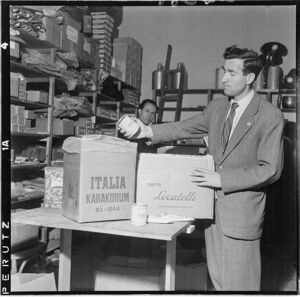 Sugli scatoloni le scritte: "Italia Karakorum K2 1954 e "Tubetto Locatelli. Triplo concentrato di pomodoro".