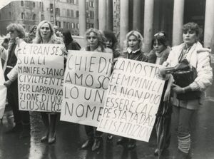 Dettaglio di tre manifestanti davanti al Pantheon, con cartelli recanti le scritte "Le transessuali manifestano civilmente per l'approvazione di una giusta legge", "Chiediamo solo un nome", "La nostra femminilità non può essere calpestata dalle istituzioni"