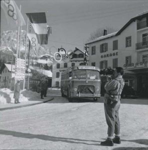 Un operatore della Rai e un pullman Fiat, adibito al trasporto del personale in servizio per i VII Giochi olimpici invernali, in una strada a Cortina d'Ampezzo