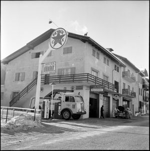 A sinistra un carroattrezzi del servizio assistenza Fiat e un'insegna Petrol Caltex .<br>