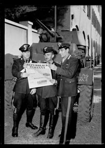 Alle spalle dei carabinieri un carrarmato.<br>