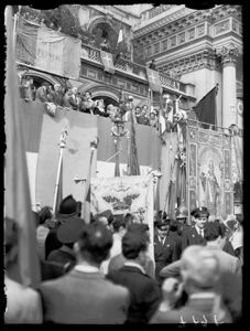 A destra lo stendardo della città di Milano raffigurante sant'Ambrogio, sopra il palco la bandiera della Repubblica Romana del 1849.<br>