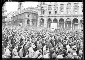 Sullo sfondo a destra, davanti al palazzo dei Portici settentrionali, il palco degli oratori e l'ingresso della Galleria Vittorio Emanuele II.<br>