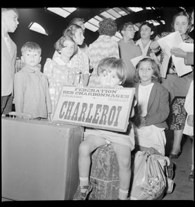 Una bambina tiene in grembo un cartello con la scritta: "Federation des charbonnage Charleroi"<br>