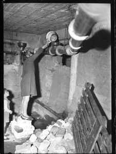 Due signori (uno in divisa) prendono delle misure con un metro di una montagna di grano<br>