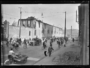 Persone, in via Carlo Farini a Milano, nei giorni dei bombardamenti, lasciano la città con ogni mezzo: a piedi, in bicicletta o con automobili