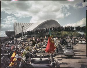 In lontananza una passerella sopraelevata gremita di persone<br>
