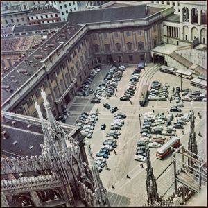 Tra le macchine parcheggiate sono presenti dei binari del tram che attraversano l'intera piazza ed imboccano un sottopassaggio situato sotto il palazzo dell'Arengario<br>