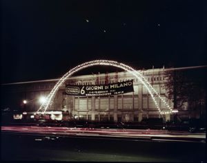 Visibile un'impalcatura ad arco luminosa ed uno striscione con la scritta "6 Giorni di Milano 2-8 febbraio 1961 Organizzazione Ignis"<br>