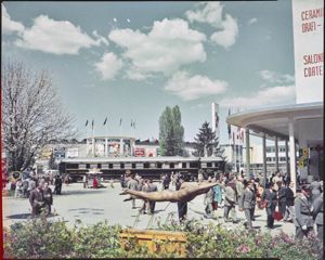 In primo piano la statua di un nuotatore, sullo sfondo l'esposizione di una carrozza ristorante<br>