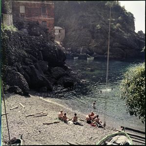 Visibili alcune imbarcazioni in legno di pescatori e delle abitazioni sulla costa montuosa<br>